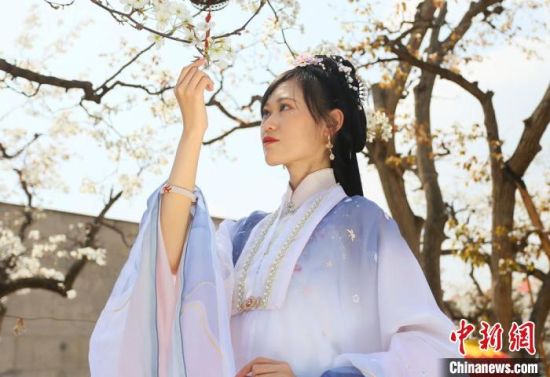 圖為蘭州青年身穿漢服在百年梨園賞景?！「哒?攝