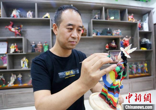 圖為安秋平正在創(chuàng)作代表隴南文縣民俗的《白馬人》作品?！「哒?攝