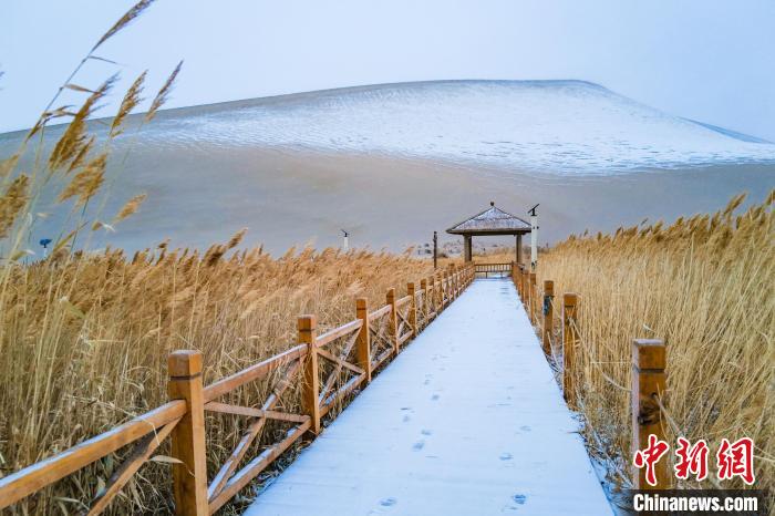 2021年11月28日，在敦煌鳴沙山月牙泉景區(qū)，沙雪交融，更顯北國風(fēng)情?！⊥醣筱y 攝