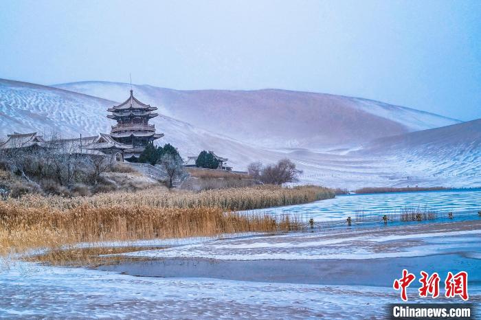 2021年11月28日，雪落鳴沙山月牙泉景區(qū)?！⊥醣筱y 攝