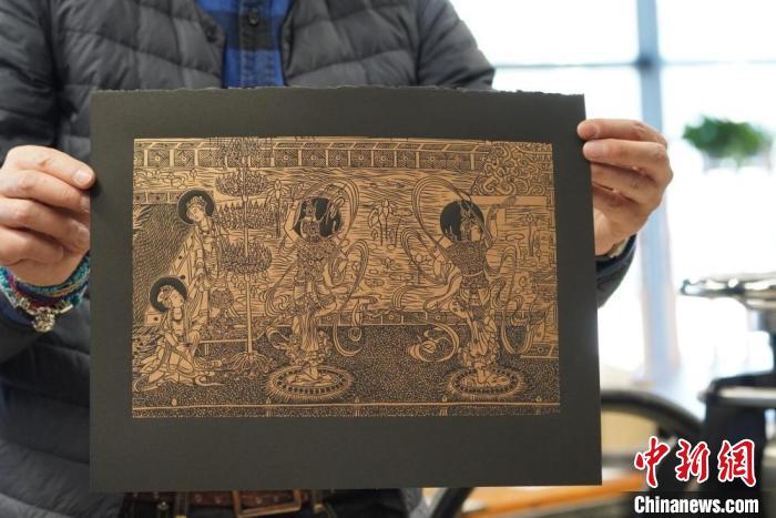 圖為手工書藝人展示敦煌雕版壁畫印刷品?！【琶赖┰?　攝