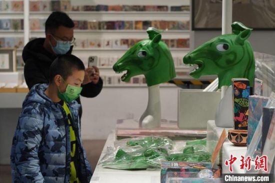 圖為“神馬來(lái)了”銅奔馬頭套吸引參觀者駐足。　九美旦增 攝