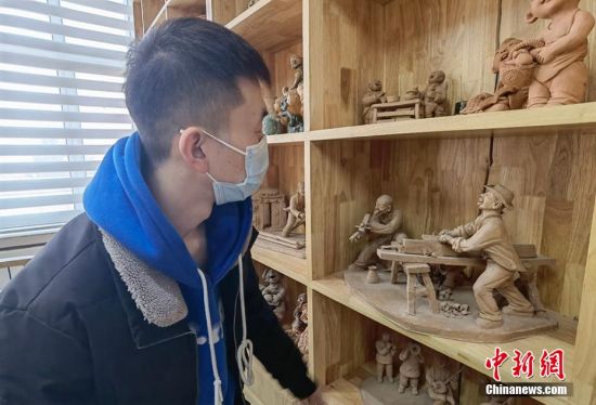 圖為學(xué)生欣賞泥塑作品。 劉玉桃 攝