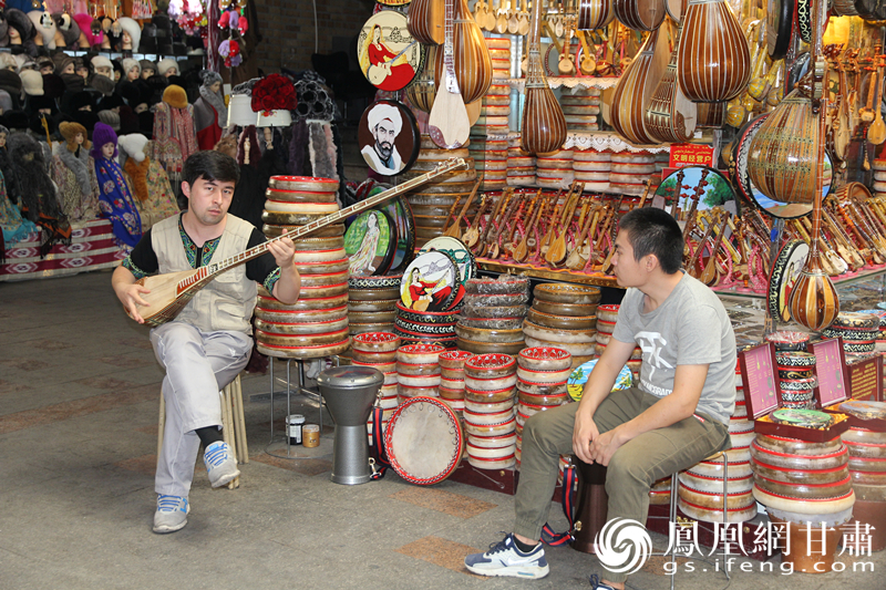 烏魯木齊二道橋巴扎內，店主正在向客人展示樂器。楊文遠 攝