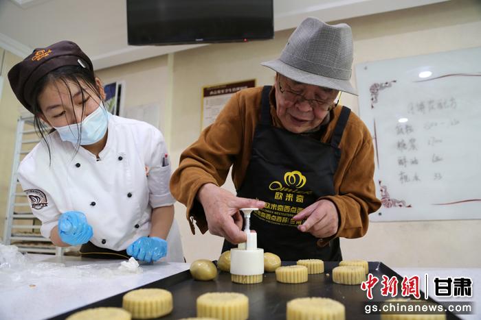 當(dāng)日，受邀參加活動(dòng)的臺(tái)胞臺(tái)屬代表、兩岸婚姻及子女、在甘臺(tái)商代表等歡聚一堂。圖為77歲的在甘臺(tái)胞潘天鑒制作月餅。九美旦增 攝