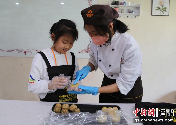 圖為在甘臺(tái)胞小朋友在工作人員指導(dǎo)下制作月餅。九美旦增 攝