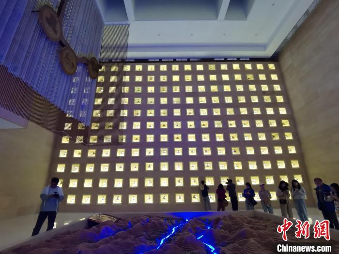 圖為河湟文化博物館序廳的左右彩陶墻放置的374件彩陶?！?zhí)砀?攝