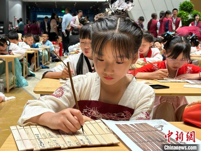 圖為小朋友在甘肅簡牘博物館練習(xí)書法?！≈行律缬浾?戴文昌 攝