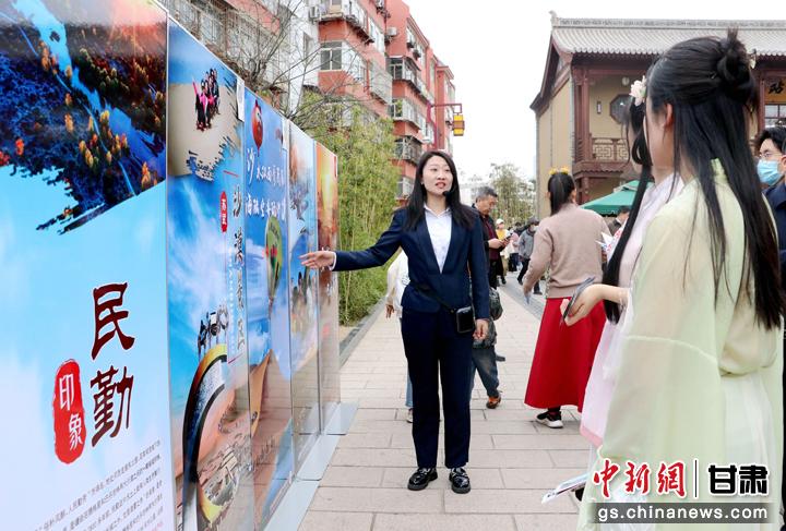 3月下旬，民勤縣在天水啟漢樓廣場舉行推介會，宣傳本地旅游資源和農特優(yōu)產品。圖為工作人員向游客介紹民勤自然風光、歷史文化。馬愛彬 攝