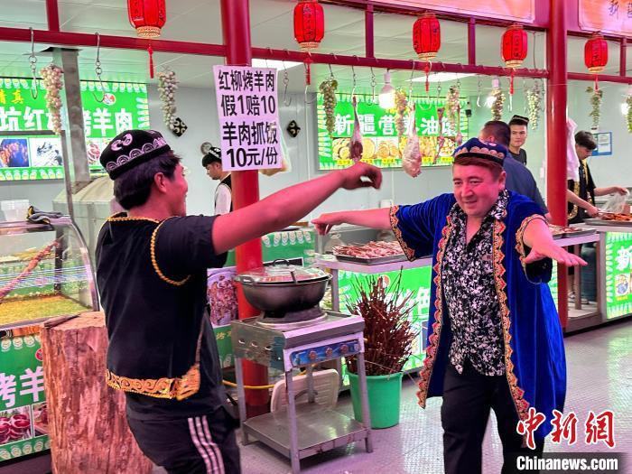 圖為餐飲經(jīng)營者在“西涼不夜城”跳起舞蹈引客。　戴文昌 攝</p><p>