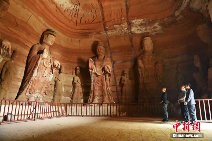 7月15日，游人參觀甘肅省平?jīng)鍪袥艽h百里石窟長(zhǎng)廊中的南石窟寺1號(hào)窟。百里石窟長(zhǎng)廊位于涇川縣境內(nèi)，由512個(gè)石窟、5眼窟中石井組成，現(xiàn)存王母宮石窟、鳳凰山石窟、南石窟寺、丈八寺石窟、羅漢洞石窟、太山寺石窟等規(guī)模較大的石窟群，還有數(shù)量眾多的小石窟群。南石窟寺開(kāi)鑿于北魏永平三年，其中1號(hào)窟屬于大型七佛窟，七佛高達(dá)6米。中新社記者 李亞龍 攝
